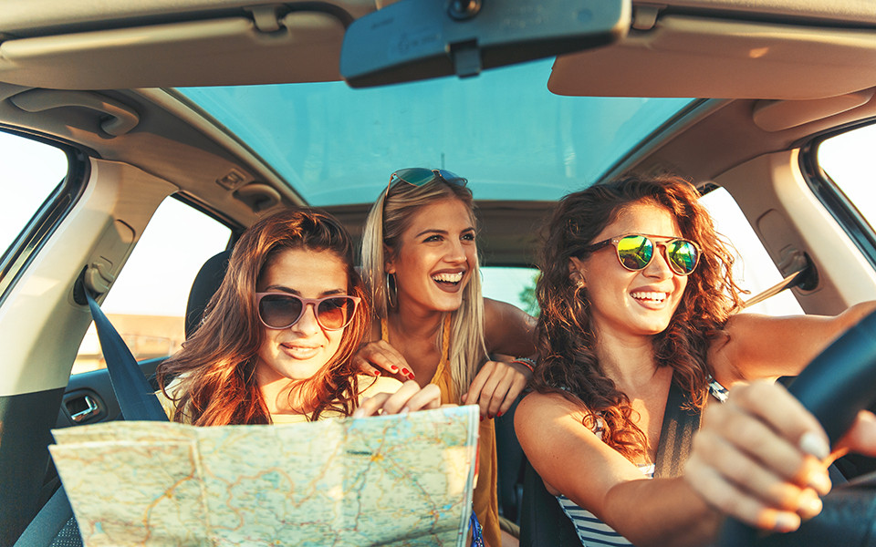 Frauen auf dem Weg in einen Kurzurlaub am Meer mit dem Auto und Eigenanreise