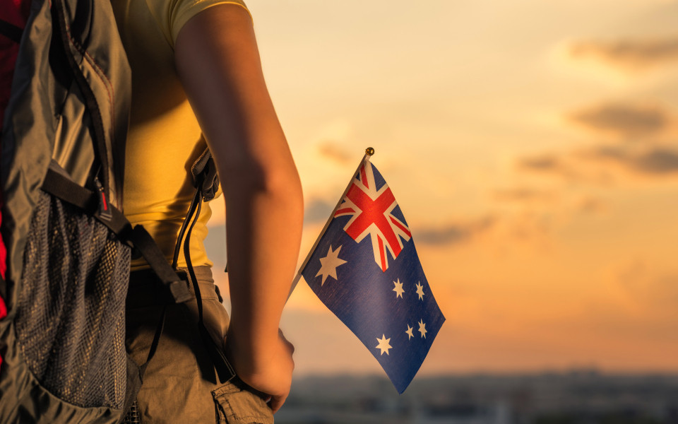 Frau mit Rucksack auf dem R&uuml;cken und Australien Fahne in der Hand